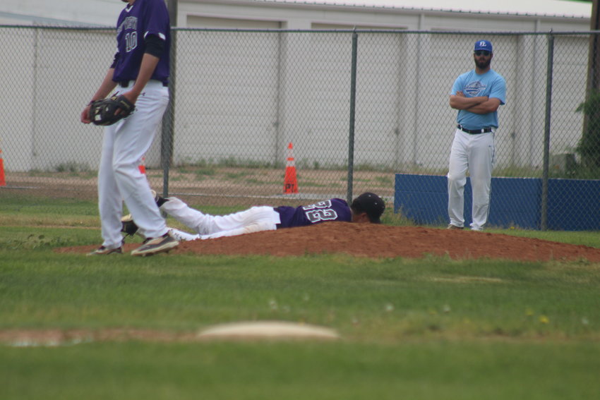 Gutierrez secures the ball as he lands on his stomach in back of the pitcher's mound.