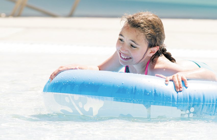 File photo of a girl smiling while lounging in one of several pools at The Splash at Fossil Trace back in 2013.