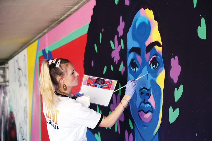 Coco Jenkins paints a mural in an underpass along the Ralston Creek Trail.