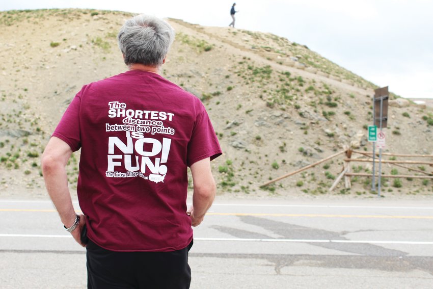 Brian O’Connor wears his Extra Miler Club shirt atop Loveland Pass on July 14. Club members like O’Connor have specific travel goals, such as visiting every county in the United States, and the group motto is, “The shortest distance between two points is no fun.”
