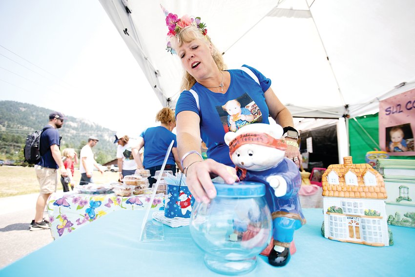 Sue Mueller reaches for a cookie jar at her stand for Suz Cookie Jar Rescue. Mueller made a business out of filling old cookie jars with homemade cookies and selling them online and at fairs.