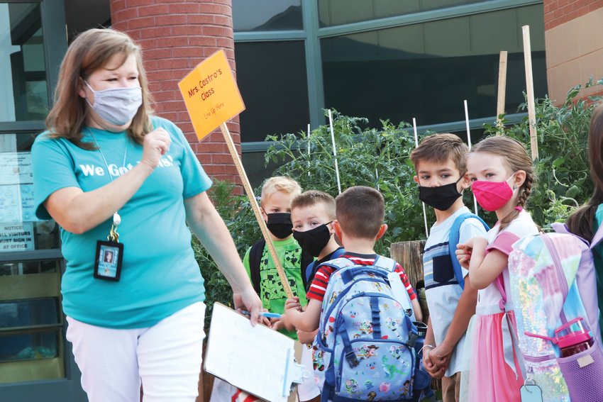 A student holds a sign that says “Mrs. Castro’s class” as others are lined up to enter Rolling Hills Elementary School Aug. 18 near east Centennial.