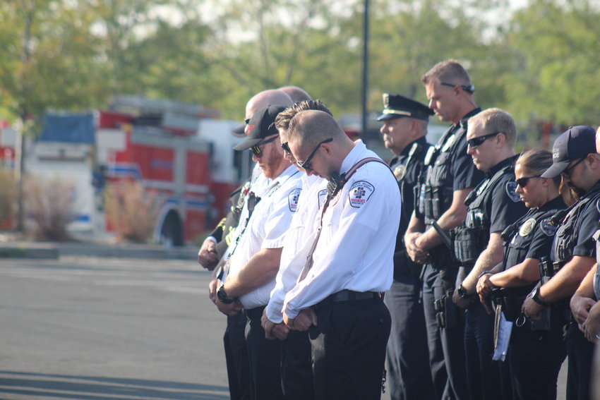 Members of the Platte Valley Ambulance Service and Brighton police reflect during the 20th anniversary of 9/11 program outside Brighton City Hall.