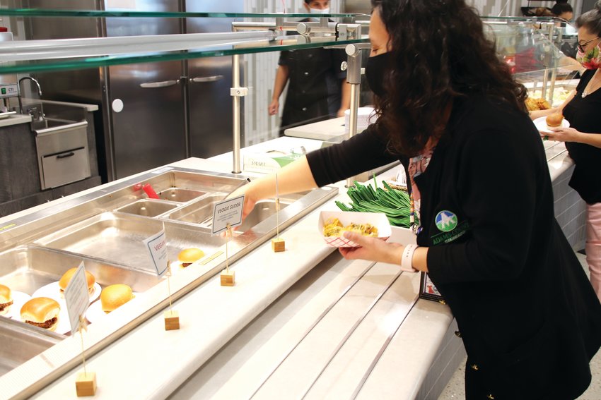 An Adams County employee makes her selection at the newly opened Mountain View Cafe in the Human Services Building in Westminster. County officials were on hand to open the cafeteria Sept. 15 that will provide jobs services and experience for food service workers.