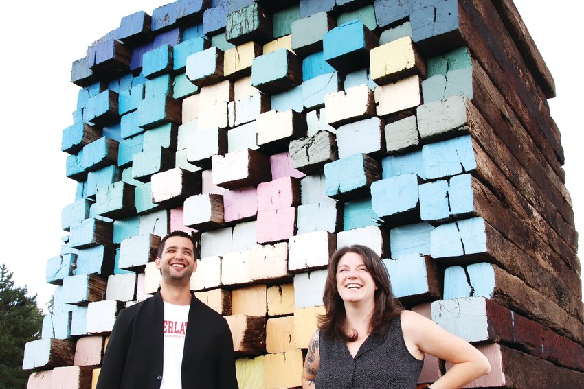 Marcus Turner, the director of communications and audience services at the Arvada Center for the Arts and Humanities, left, and Emily Grace King, exhibition manager for the Arvada Center, stand Sept. 16 near a sculpture at the center’s “sculpture field.” The piece by Scottie Burgess, made with railroad ties and wood paint, is titled “Ties Forward.”