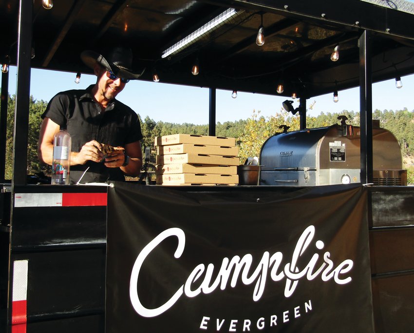 Jared Leonard, owner of Campfire Evergreen samples the pizza he is preparing to serve at the food-tasting event.