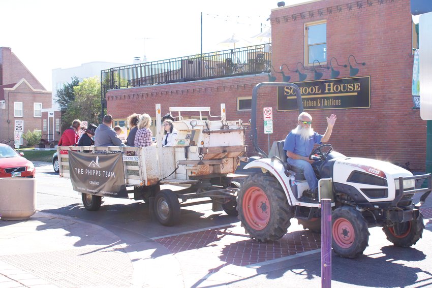 A tractor drives by the festival with costumed youngsters.