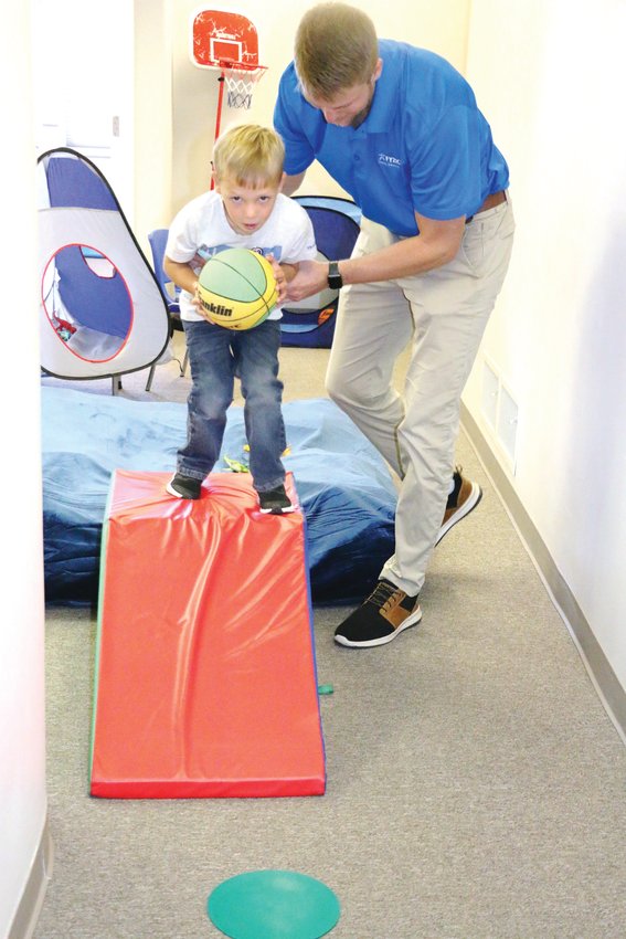 Taylor Pfeifer works with a young patient in physical therapy at the ­FYZICAL Therapy &amp; Balance Center in Castle Rock.