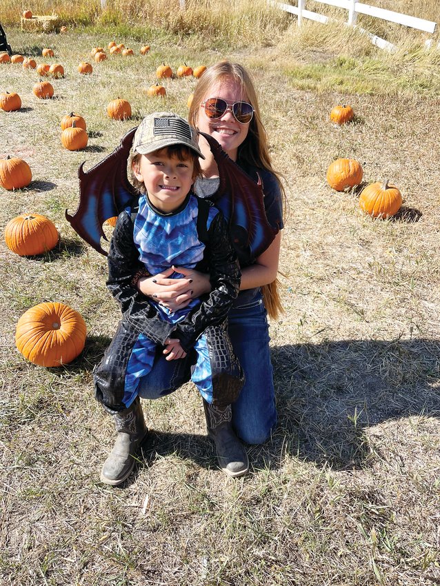 Lorin and Liam Ringor pose together in front of the Kiowa Harvest Festival pumpkin patch.