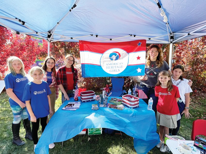 Elizabeth-based American Heritage Girls troop members stand in front of their booth where they give children painted tattoos at the Kiowa Harvest Festival.