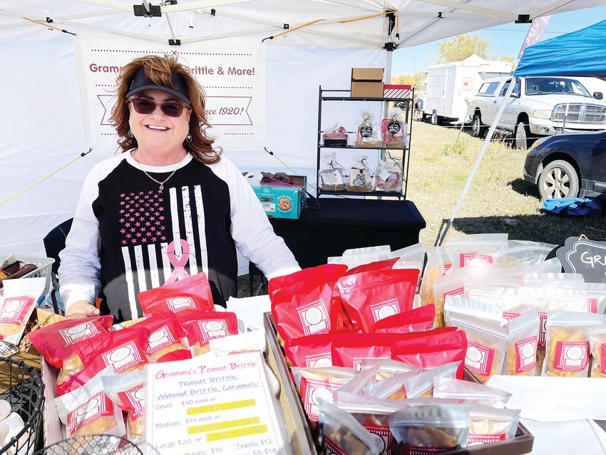 Lori Hammett of Grammy’s Brittle &amp; More standing proudly under her tent.