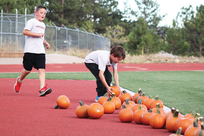 Jake Crumpton and John Lloyd, both third-graders at King-Murphy Elementary School, run to grab pumpkins for the final stretch of the Oct. 22 Pumpkin Run at Clear Creek High School. The Pumpkin Run was the final event for King-Murphy and Carlson elementary schools' combined cross country club.