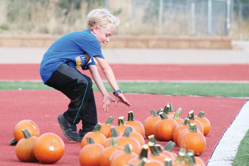 Sawyer Koeberl, a third-grader at Carlson Elementary, runs to grab a pumpkin for the final stretch of the Oct. 22 Pumpkin Run at Clear Creek High School. Second and third graders in the cross country club ran approximately a mile around the school and nearby trail before returning to the stadium, grabbing a pumpkin, and carrying it to the finish line at the other end of the field.