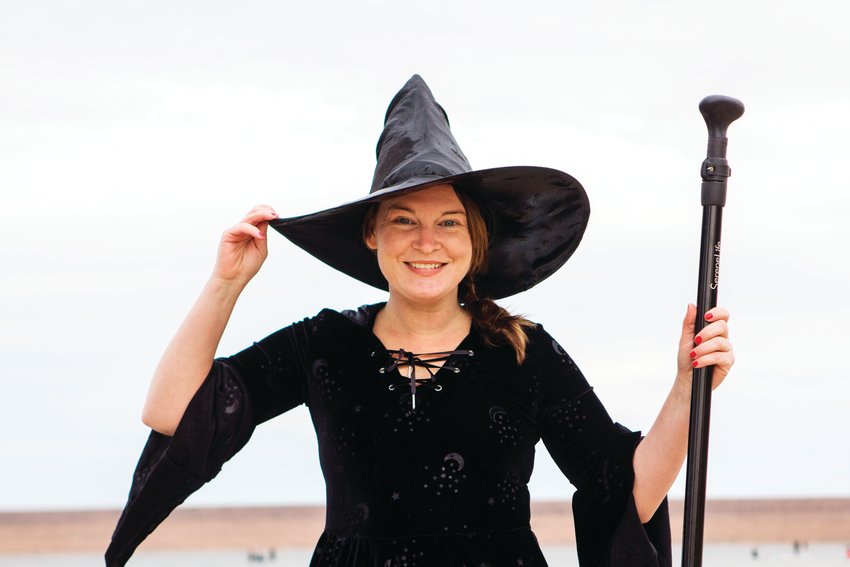 Ashley Dodson holds onto her hat on a windy, witchy morning at Chatfield reservoir during a "witchy" standup paddleboard event.