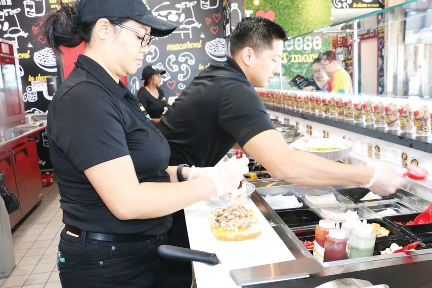 Working together, General Manager Pino Chinnel and owner Vu Tran of I Heart Mac &amp; Cheese work to fulfill orders.