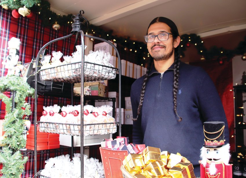 Ryan Anderson of The House of Stewart stands with the small business’ display of candies and confections at its booth at this year’s Cherry Creek Holiday Market. Anderson’s favorite is the Baileys Irish Cream because it is the company’s seasonal product — it’s only made in the fall.