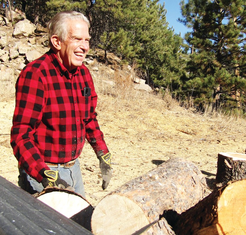 Mike Wells smiles as he moves the wood.