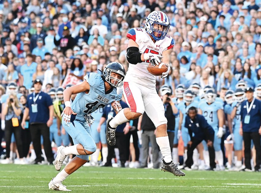 Cherry Creek’s Max Rodridguez, 13, pulls in the first TD of the day as he falls to the endzone with Valor Christian’s Carter Forsythe, 43, in pursuit.
