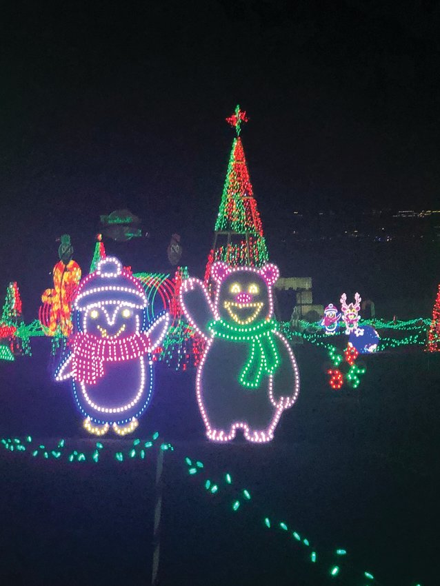 Friendly holiday creatures look on as cars roll through the lights display.