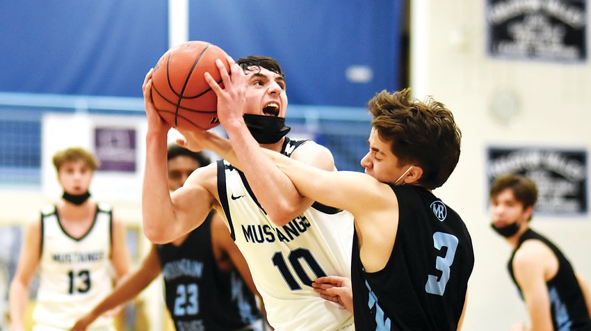 Ralston Valley freshman Tanner Braketa, 10, is fouled by Mountain Range junior Joel Sotelo while driving the lane in the first half Dec. 16 at Ralston Valley High School. Braketa scored 17 points in the Mustangs' 78-41 victory to advance to the championship game of the Ralston Roundup.