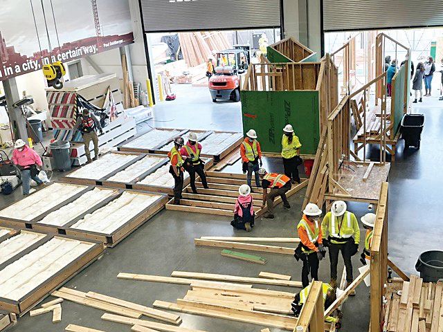 A top-down view of students working on the tiny-home project.