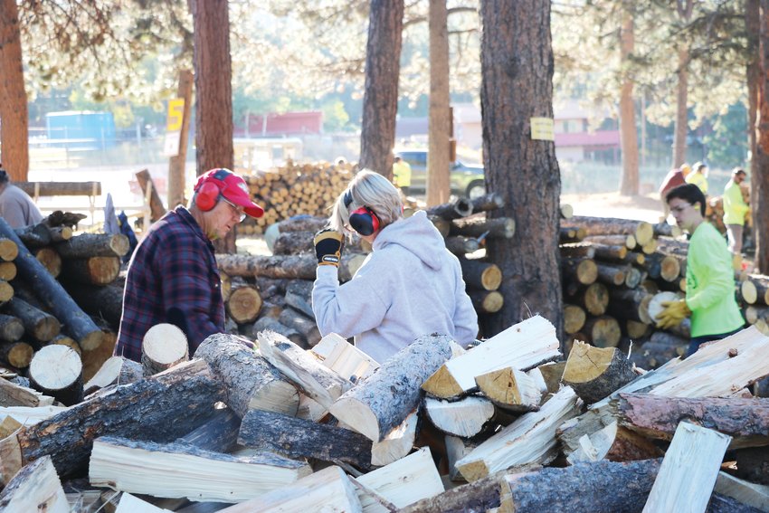 Volunteers load wood onto a trailer at the annual Split &amp; Steak at Conifer Community Church. More than 100 volunteers work to provide firewood for area families in need.