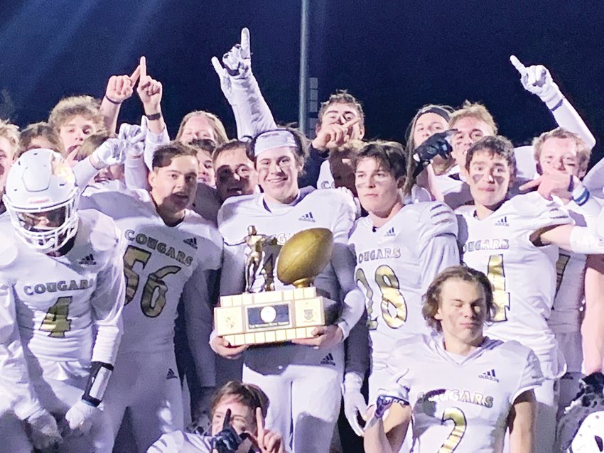 The Evergreen High School football team hoists the Mountain Bowl trophy after beating their cross-town rivals Conifer, 24-19, in November.