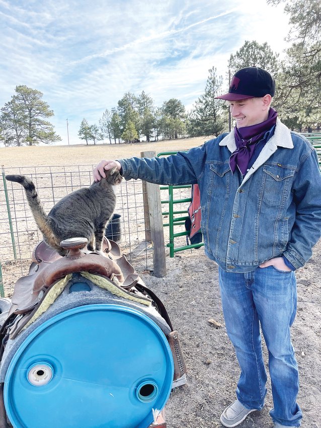 Brian Gillen's family ranch in Elizabeth has dozens of animals. Mittens, one of his family's six cats, gets a head scratch from Gillen.