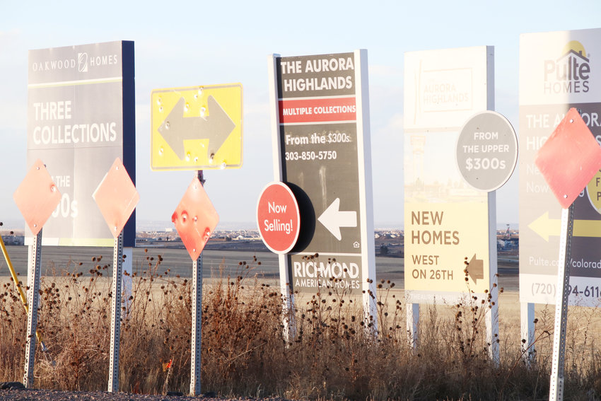 Signs advertising new homes in the area sit Dec. 29 at the intersection of Powhaton Road and 26th Avenue, not far from Adams County's highest-elevation point.