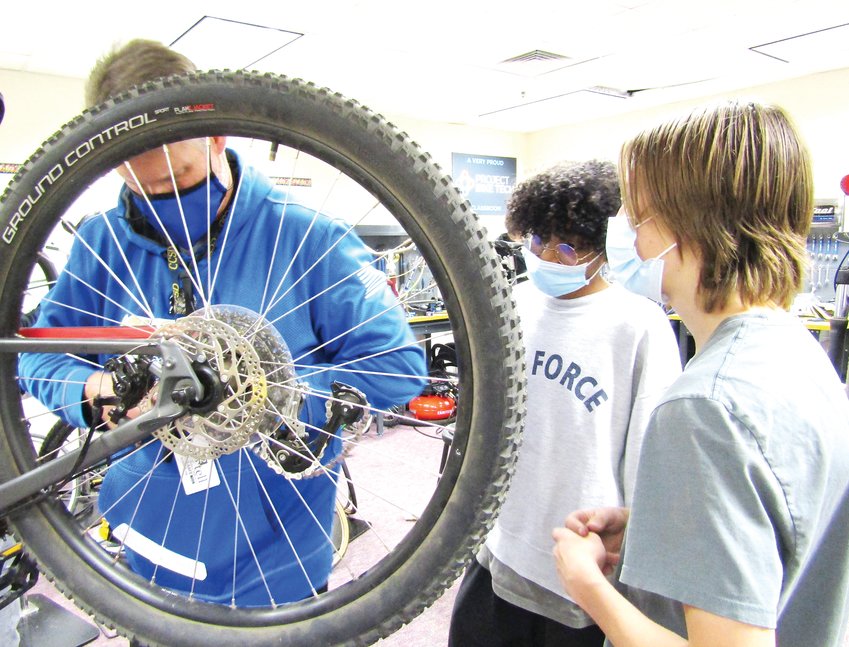 Project Bike Tech teacher Brian Inman works with sophomores Dominic-Carl Troia and Xander Taylor to fix a bike during a recent class.