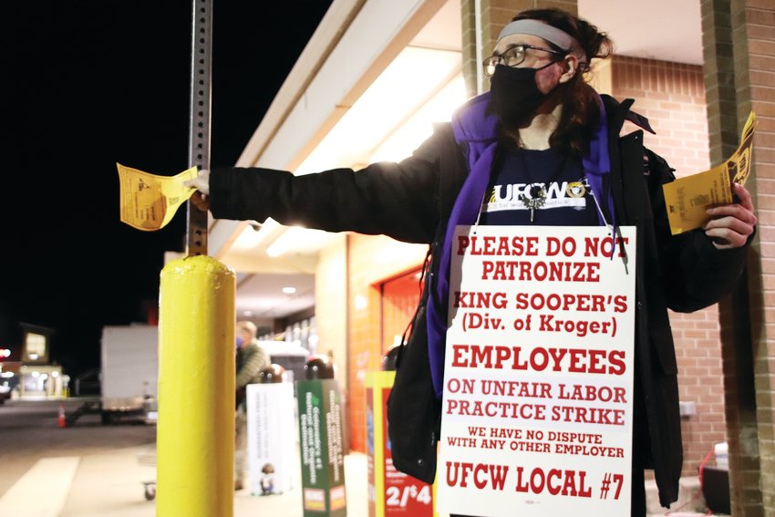 A King Soopers worker hands out leaflets Jan. 12 at the store on Arapahoe Road near Holly Street in support of a union strike against the grocery store chain. A handful of workers were gathered in front of the store in support of the strike that evening.