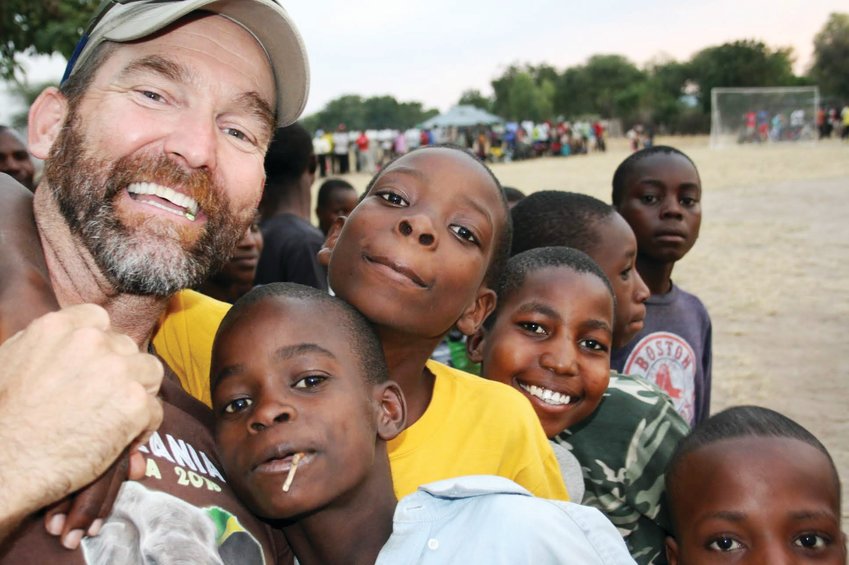 Dave Johnson, founder of the Katie Adamson Conservation Fund (KACF), poses with locals in Tanzania for a community soccer game, which was put on by one of KACF’s 25 global partners that benefit local community growth and wildlife conservation.