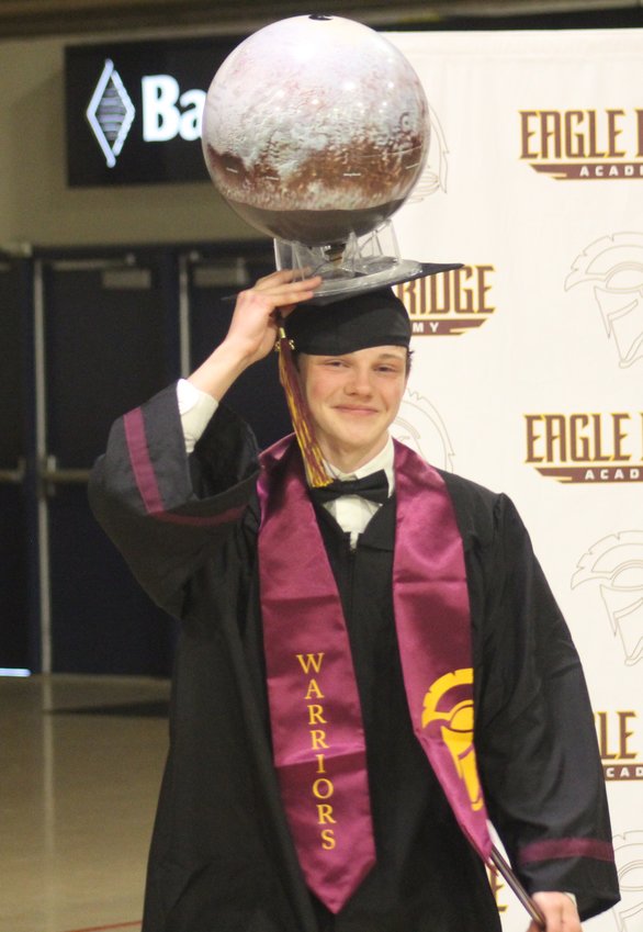 Eagle Ridge Academy graduate Nathaniel Hershey has one hand on the diploma and one hand on his "tassel" at the school's commencement program at Bank of Colorado Arena in Greeley on May 18.