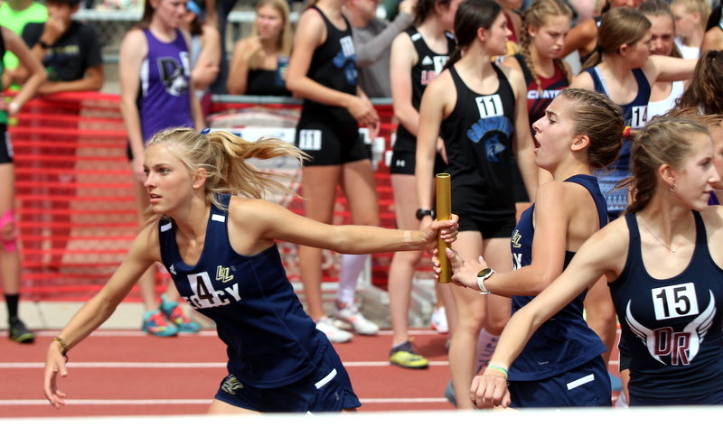 Legacy's Mia Meraz hands the baton to Addison Dolan in the 4-by-800-meter relay May18 at the state 5A track meet in Lakewood. The Lightning finished sixth.