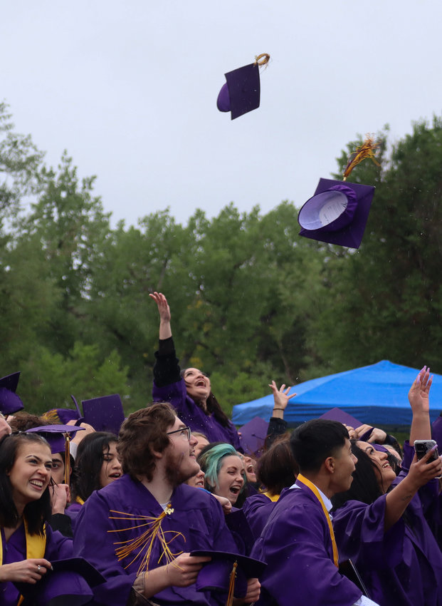 Graduates throw their caps in celebration.