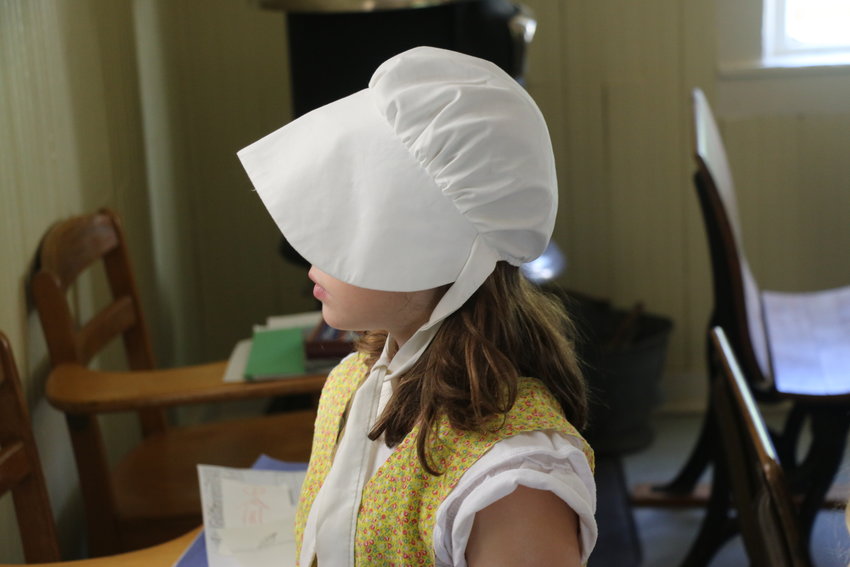 The students wore clothing similar to what children in the 1900's would have worn to school.