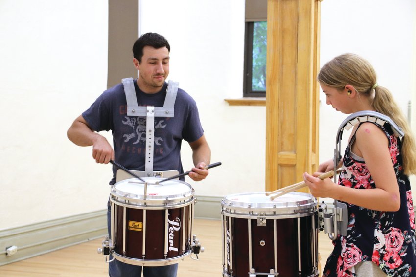 Evan Schrieber, a drum instructor with the Colorado Youth Pipe Band, left, works one-on-one with Zivah Palmer.