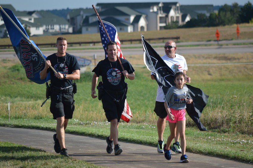 The “RexRun for PAWSitivity” event began with a memorial run in honor of K-9 Riggs, a member of Greenwood Village Police Department who passed away earlier this year. Theresa Ann Babcock, 9, is part of the nonprofit “Running 4 Heroes” and ran alongside Arapahoe County Sheriff Tyler Brown, right, Deputy Travis Jones, center, and Deputy John Gray, left.