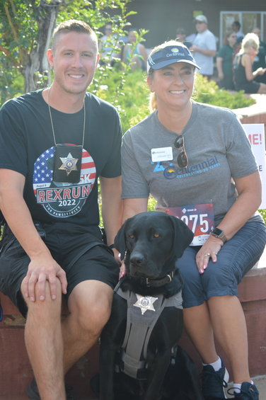 Deputy John Gray and therapy dog Rex pose with Stephanie Piko, the mayor of Centennial, during the “RexRun for PAWSitivity” event, held Aug. 6 at Dove Valley Regional Park.