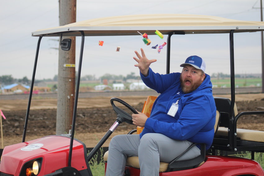 Fort Lupton assistant principal/athletic director Rick Jacoby tries out his throwing arm during the school's homecoming parade Sept. 9.