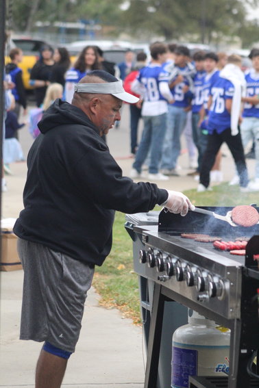 Lenny Bachicha prepares a batch of hamburgers for the Fort Lupton High School Booster Club's barbecue supper/raffle ahead of the Bluedevils' homecoming football game Sept. 9.