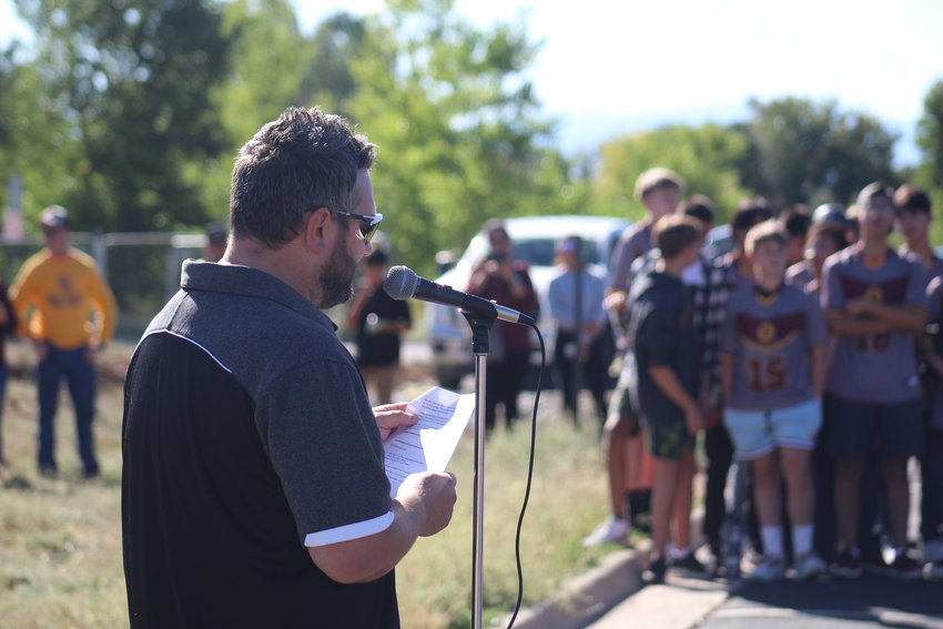 Eagle Ridge Academy Athletic Director Zach Henning talks about the advantages of the new soccer field as members of the boys soccer team wait in the wings for a chance to turn shovels of dirt.