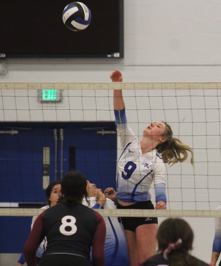 Fort Lupton's Payton Faulhaber spikes one against the defense of Bruce Randolph's Maria Bonilla (8) during the Bluedevils' three-set win Sept. 29.
