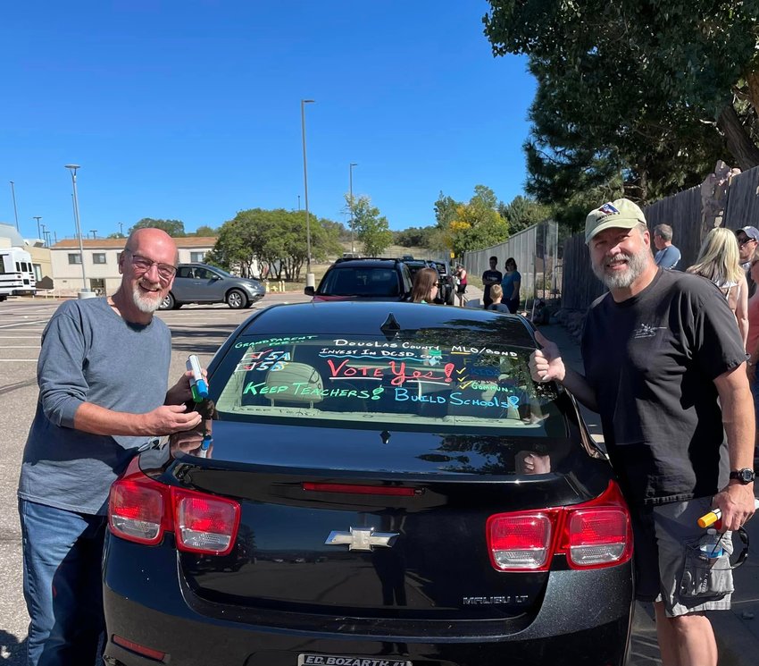 Douglas County School Board members David Ray, left, and Mike Peterson paint cars on Sept. 24 to show support for the district's bond and mill levy override. Since the funding questions failed this year, the school board indicated at its winter retreat that they would return to voters in 2023.
