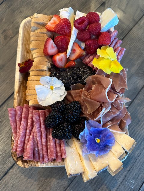 One of Melissa Clement’s favorite ways to make her charcuterie visually appealing is to add edible flowers. She also likes to mix textures and flavors by including hard and soft cheeses, as well as sweet and spicy pairings.