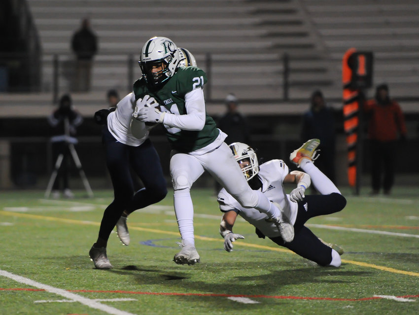 Pine Creek running back Jonathan Coar splits a pair of Legacy defenders en route to a first-quarter touchdown, during a CHSAA 5A playoff game at District 20 Stadium in Colorado Springs. The Eagles dashed the Lightning’s playoff run, 30-24.