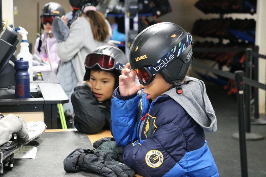 One student dons his helmet and goggles before hitting the slopes.