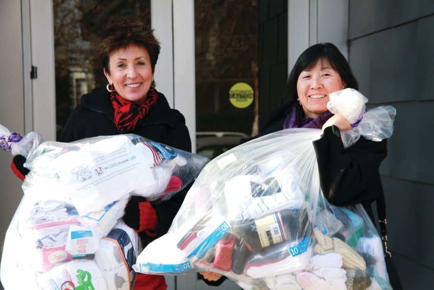 Sue Lee, left, and Phillis Shimamoto carrying socks in 2012.