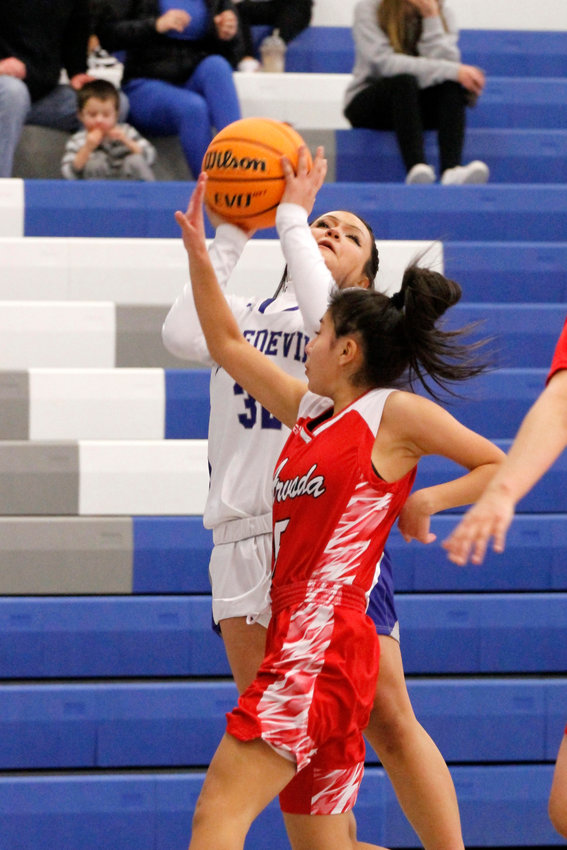 Fort Lupton sophomore Serenity Gallegos (32) manages to get a shot in while being defended by Arvada senior Maryan Francisco-Castillo (5). The Bulldogs defeated the Bluedevils 37-22 in their league match Jan. 19.