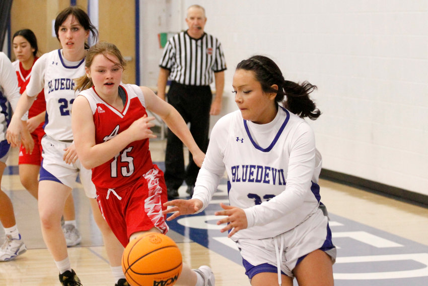 Fort Lupton sophomore Serenity Gallegos (32) catches a rebound while being chased down by Arvada's Taylor Dye (15). Arvada defeated Fort Lupton 37-22 during their league match on Thursday Jan. 19th, 2023.Jan. 19.